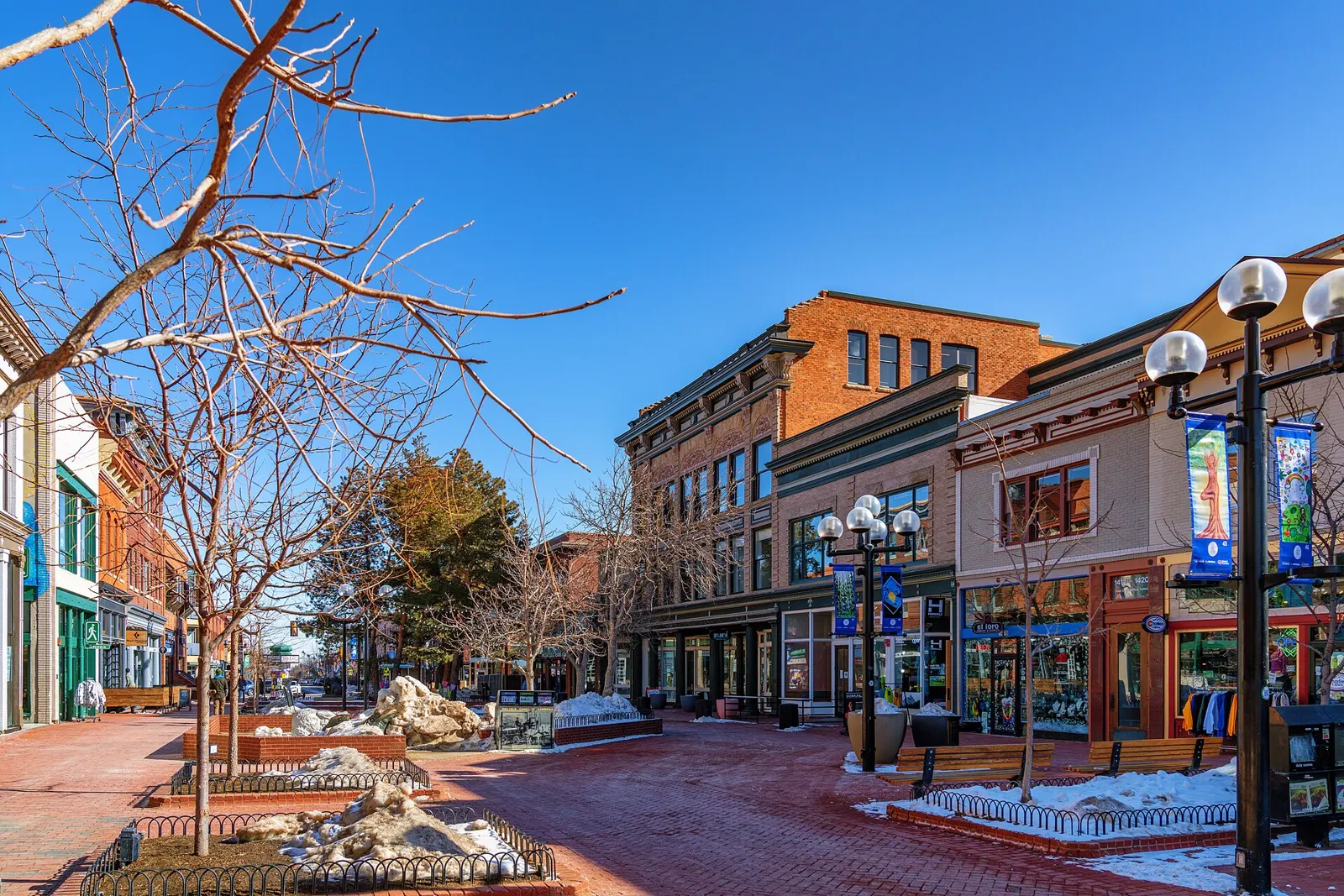 Brick storefronts and lampposts along the Pearl Street Mall in downtown Boulder on a sunny winter day