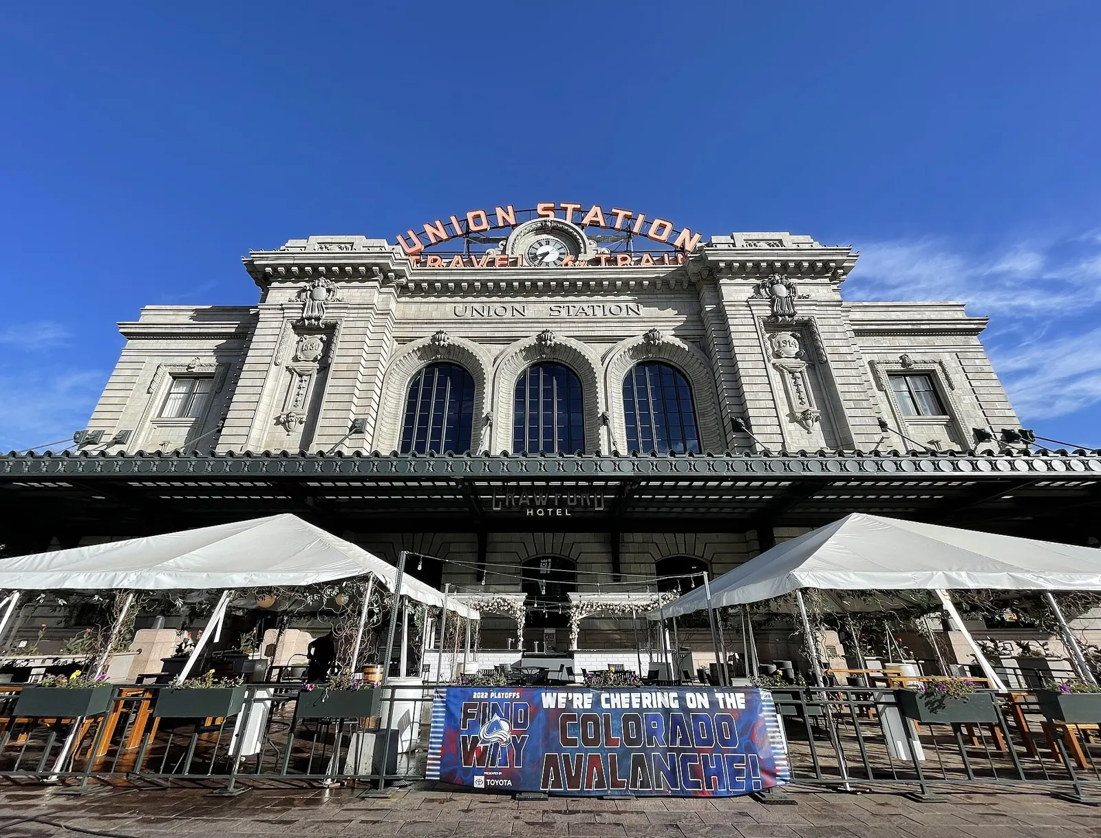 Denver Union Station's historic Beaux-Arts facade with its red Union Station sign and outdoor patio tents in downtown Denver
